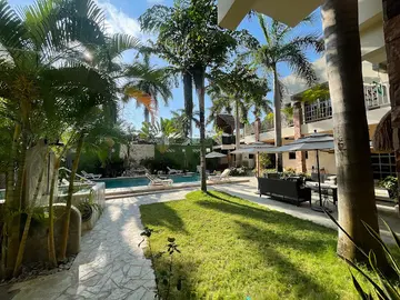 Palm-lined courtyard, pool and seating at Beond in Cancun