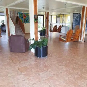 Open sitting area with wooden rocking chairs at Iboga Wellness Center.