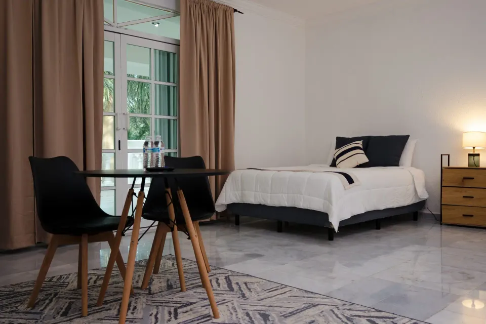 Guest bedroom with a bedside table and seating at Ibogaine Clinic by David Dardashti