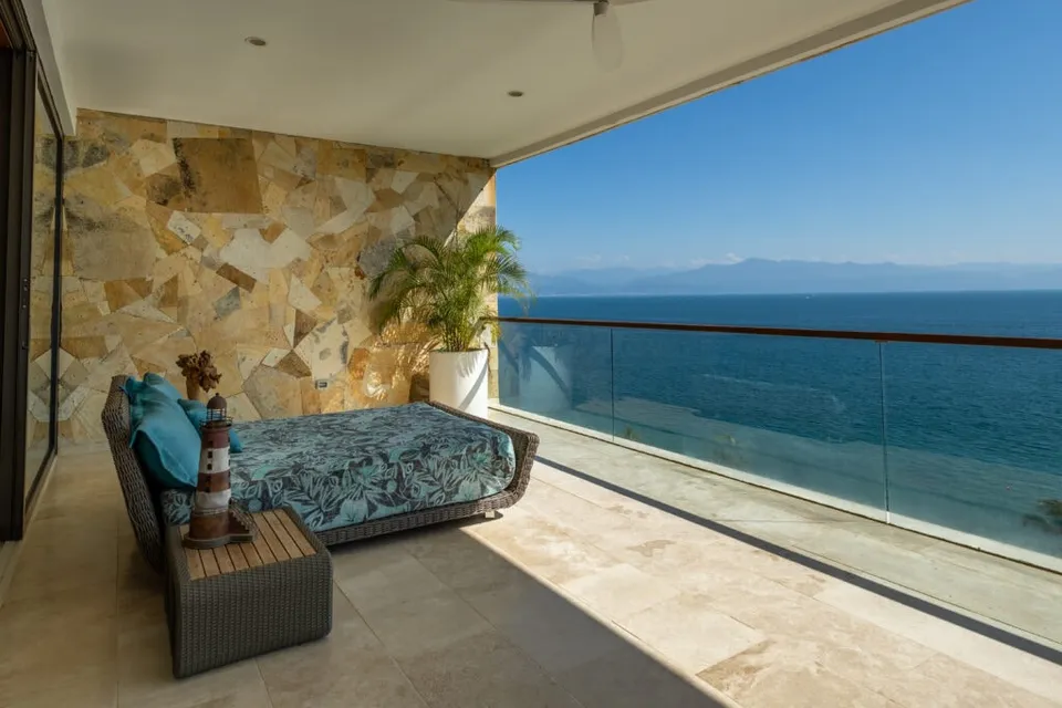 Covered terrace with lounge seating and an ocean view at the Kambo Wellness Center retreat venue