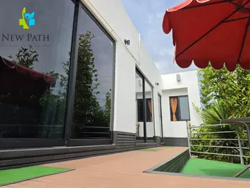 Garden deck and white guest-room buildings at New Path Ibogaine
