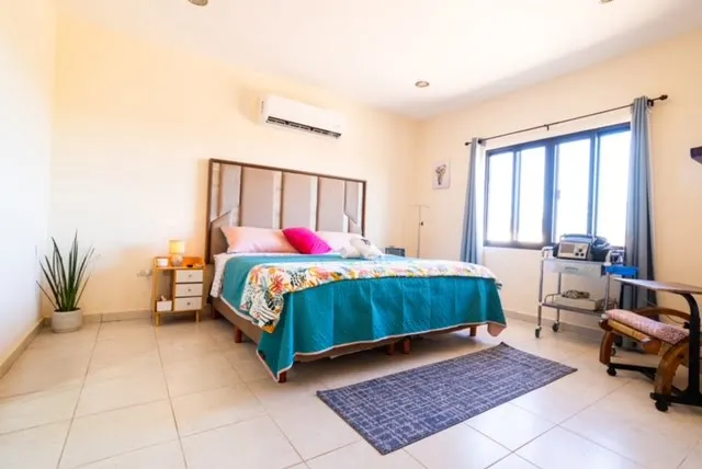 Guest bedroom with a turquoise bedspread and bedside equipment at Viraha Wellness Center